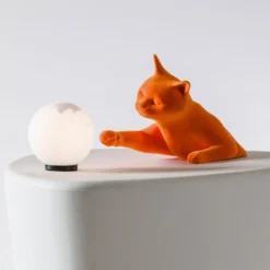 Karman Tischleuchte Maoo, Keramik orange, Glas, Katzenfigur