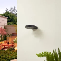 Lucande LED-Solar-Wandlampe Tavon, rund, schwarz, Sensor