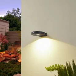 Lucande LED-Solar-Wandlampe Tavon, rund, schwarz, Sensor