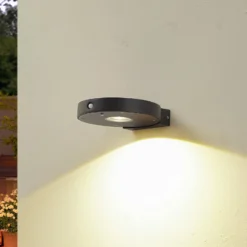 Lucande LED-Solar-Wandlampe Tavon, rund, schwarz, Sensor