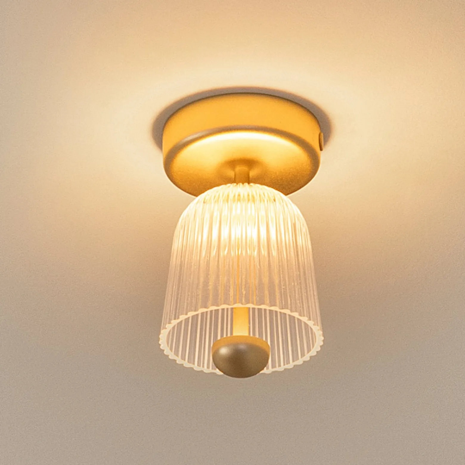 Nuura LED-Deckenlampe Asteea, Ø 12 cm, messingfarben/klar